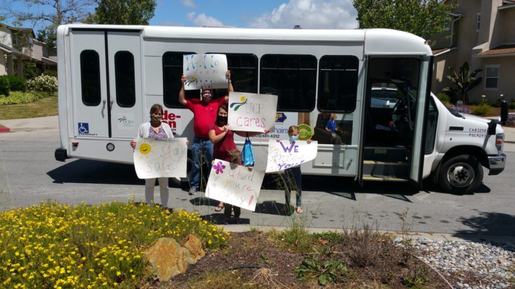 UCP Staff holding up signs to greet members at their homes during the UCP Parades