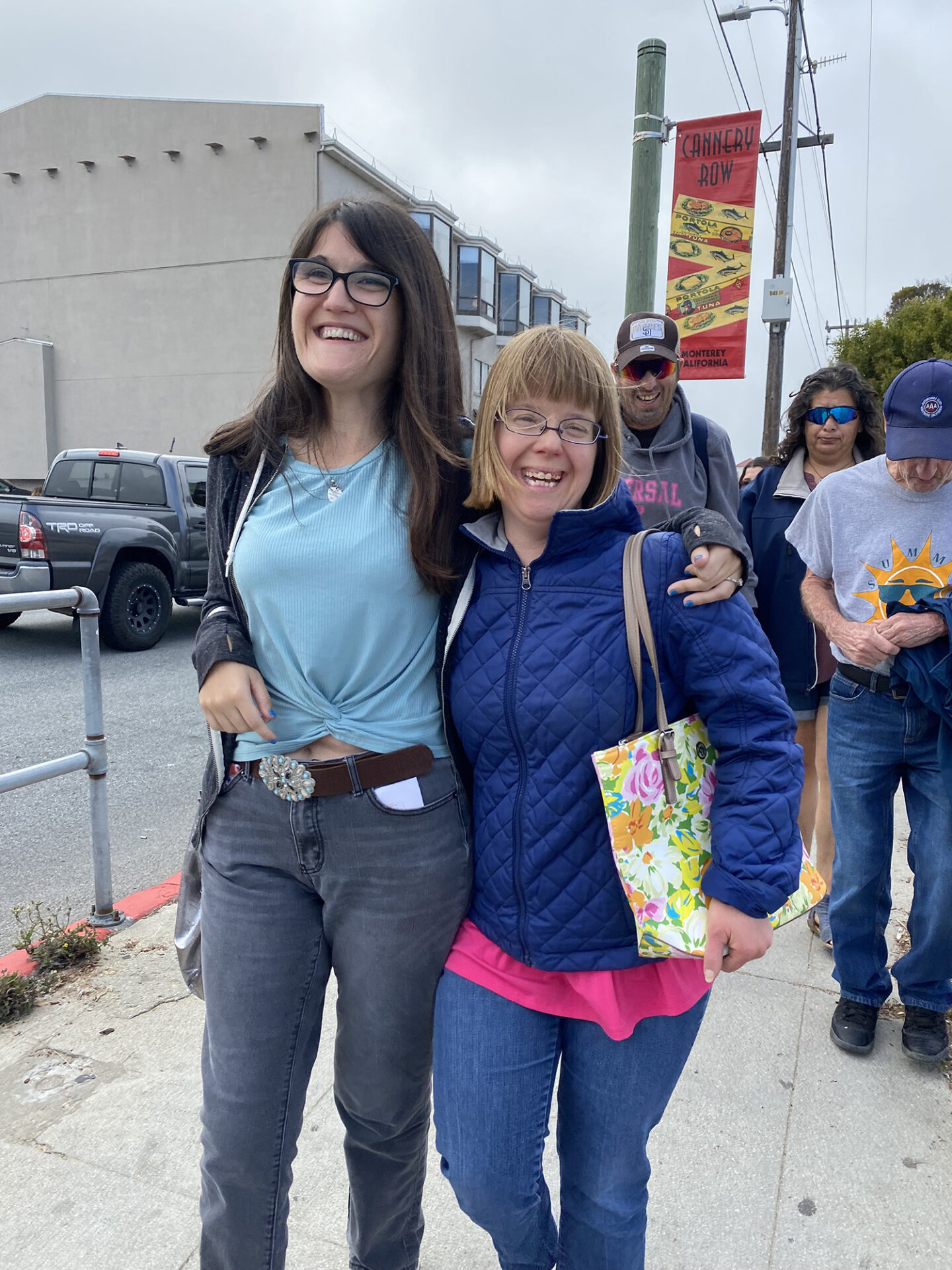Makayla and Amy in an embrace walking on a sidewalk