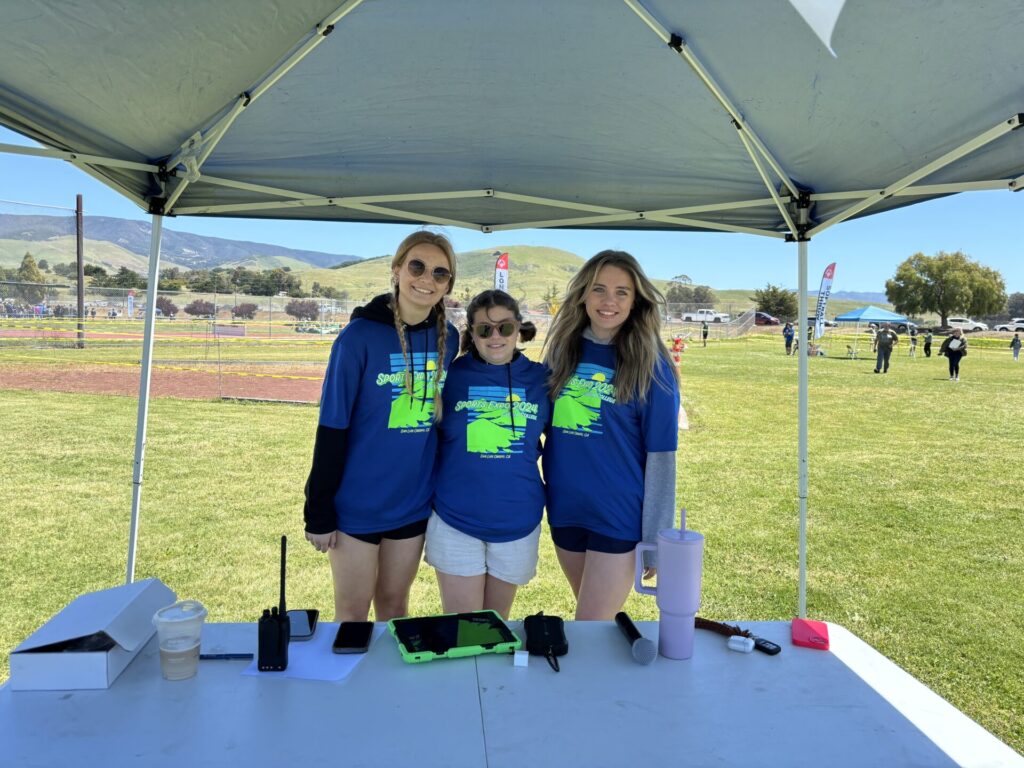 Volunteers smiling for the camera as they support athletes
