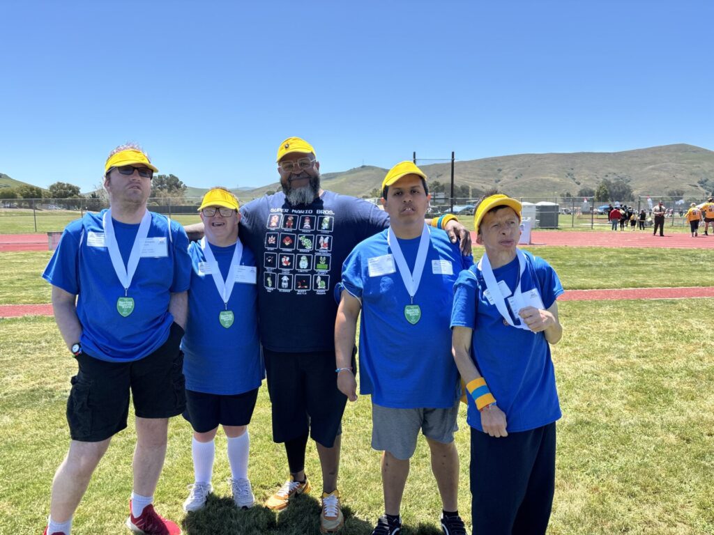 CALL Team posing together in matching shirts all showcasing their medals